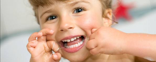 Child flossing their baby teeth.